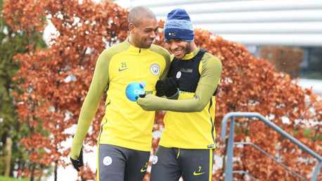 MATES: Fernandinho and Raheem Sterling share a joke