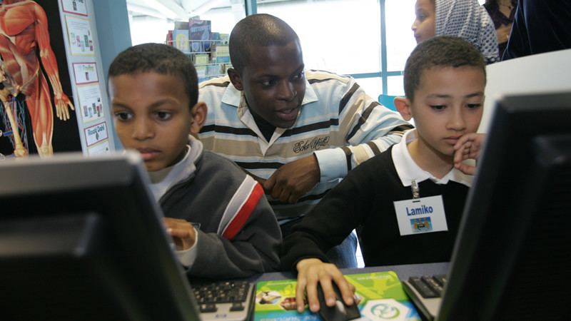 Nedum Shows some bluezone kids how to use a computer
