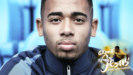 Gabriel Jesus holds up his City shirt in the dressing room