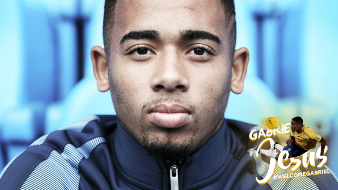 Gabriel Jesus holds up his City shirt in the dressing room