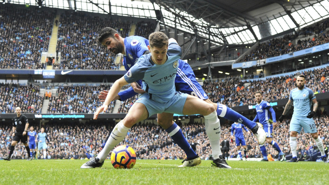 BATTLE: John Stones shepherds the ball out, under pressure from Diego Costa