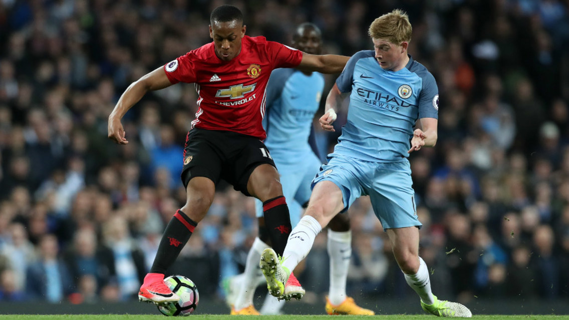 APPLYING THE PRESSURE: Kevin De Bruyne looks to force Martial into a mistake.