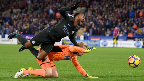 PENALTY: Raheem Sterling is brought down by 'keeper Jonas Lossl and referee Craig Pawson points to the spot.