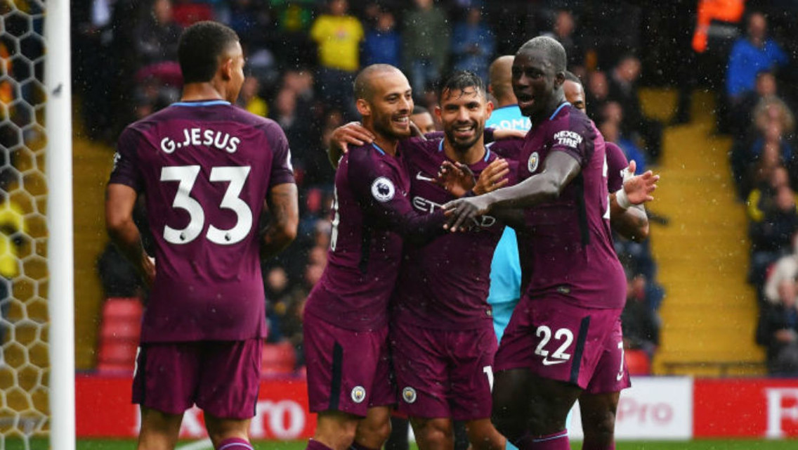 SMILING ASSASSIN: Sergio Aguero is mobbed by his City team-mates
