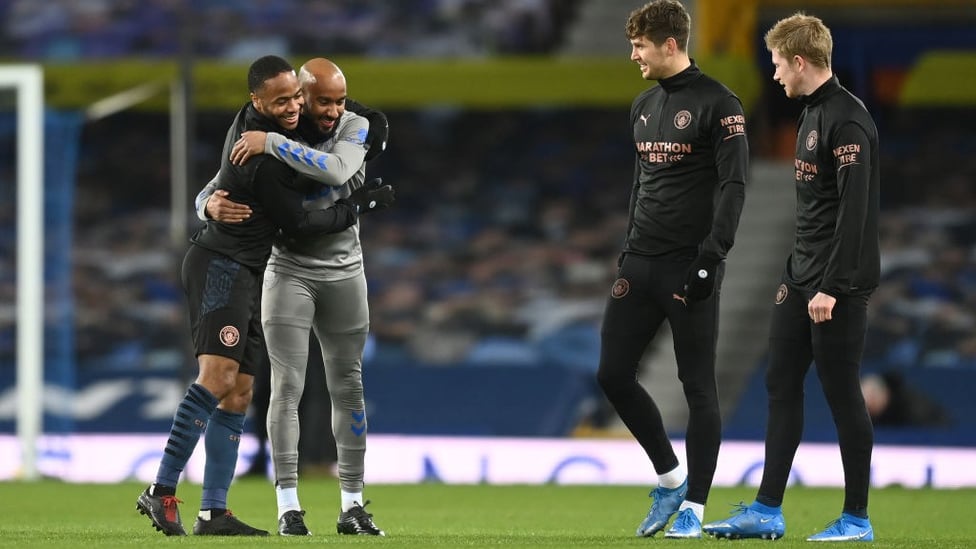 OLD FRIENDS : Raheem Sterling embraces with former City man, Fabian Delph ahead of kick-off.