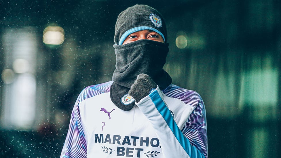 WELL DRESSED : Raheem Sterling protects himself from the elements.