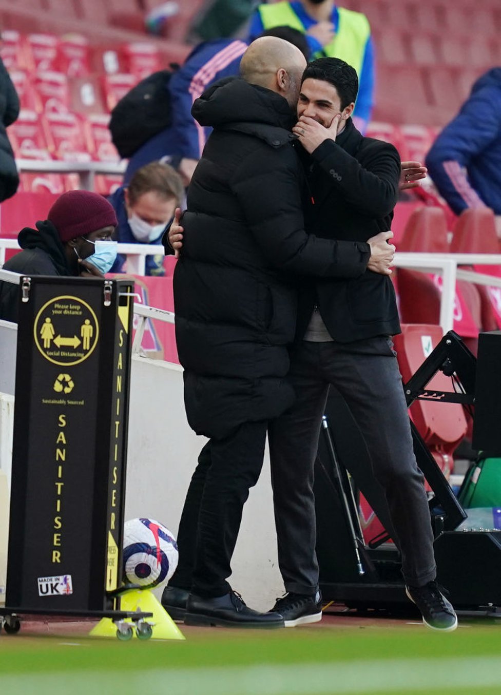 REUNITED : Guardiola and Artera share a warm embrace on the touchline.