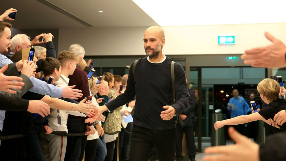 HI FIVE : Pep is greeted upon arrival at the Etihad Stadium