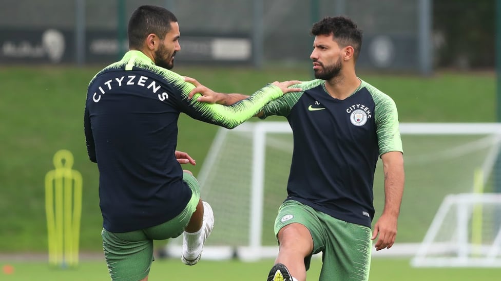 BROTHERS IN ARMS : Ilkay Gundogan and Sergio Aguero stretch off