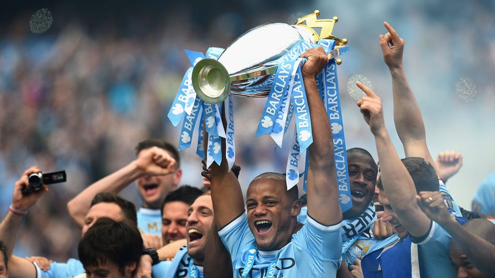 THAT WINNING FEELING : Vincent Kompany hoists the Premier League trophy aloft in 2014.