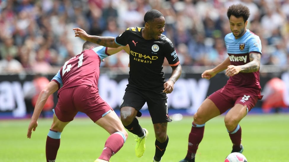 QUICK FEET : Raheem Sterling skips past a pair of challenges.