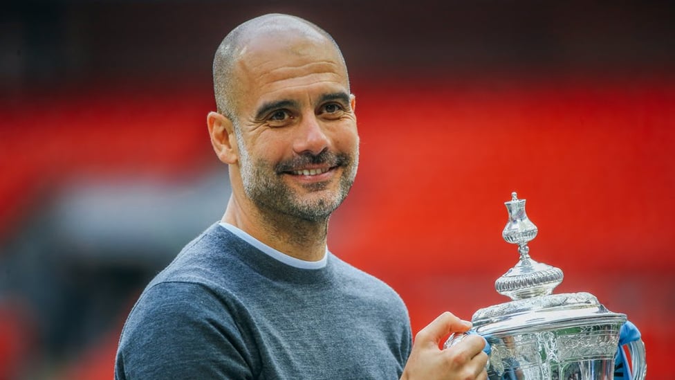 GUARDIOLA GRIN : Pep gets his hands on the cup