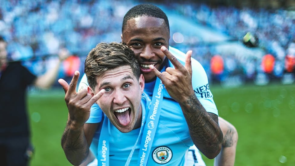 PIGGY BACK : John Stones celebrates his first Premier League title with Raheem Sterling.