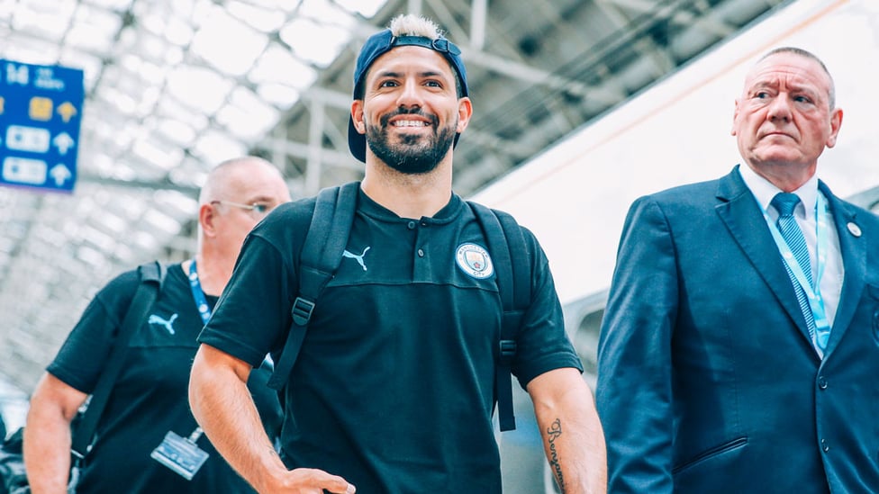HAT'S THE WAY TO DO IT : Sergio Aguero is all smiles as he prepares to board the train to London