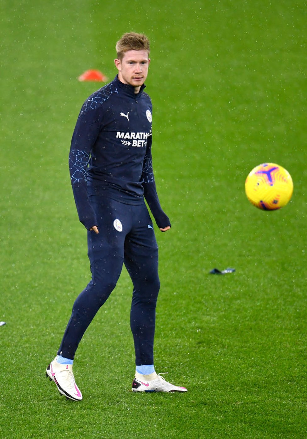 HOME ALONE : Kevin loosens up individually during the warm up in the pouring Manchester rain.