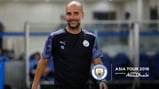 ALL SMILES: Pep Guardiola heads out to training in China.