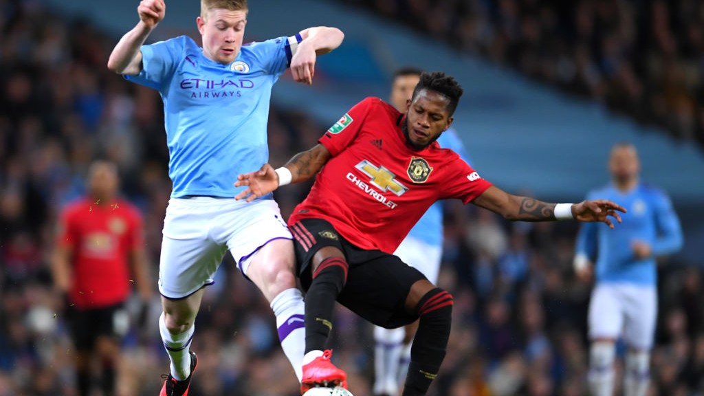 TUSSLE : De Bruyne challenges Fred for the ball in midfield_