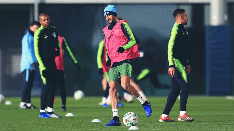 HATS THE WAY TO DO IT : Riyad Mahrez limbers up while wearing some nifty head gear