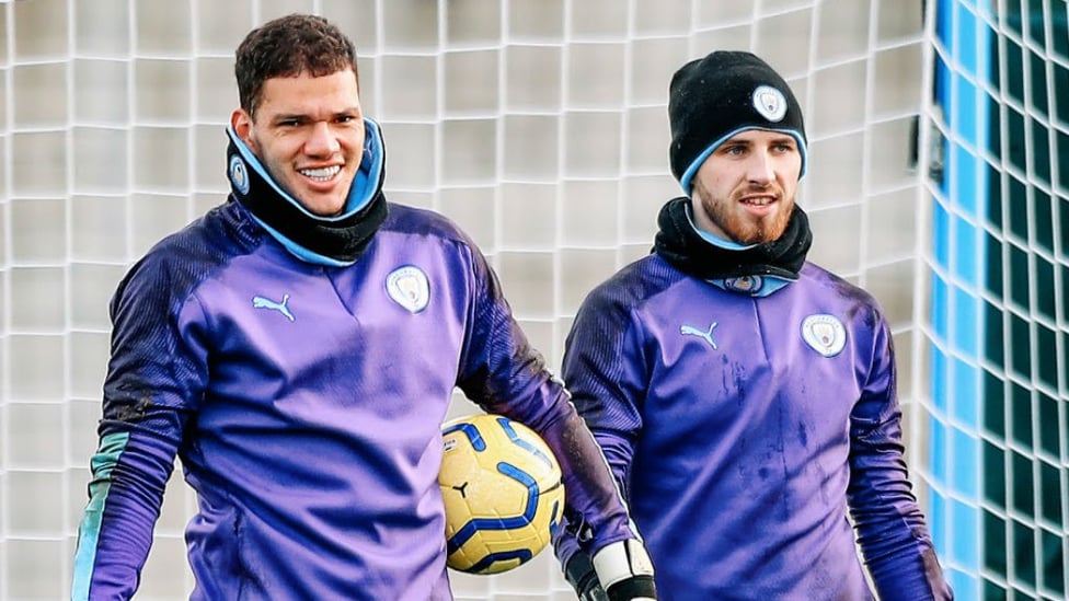 TWO'S COMPANY : Ederson and Daniel Grimshaw were wrapped up to keep out the winter chill