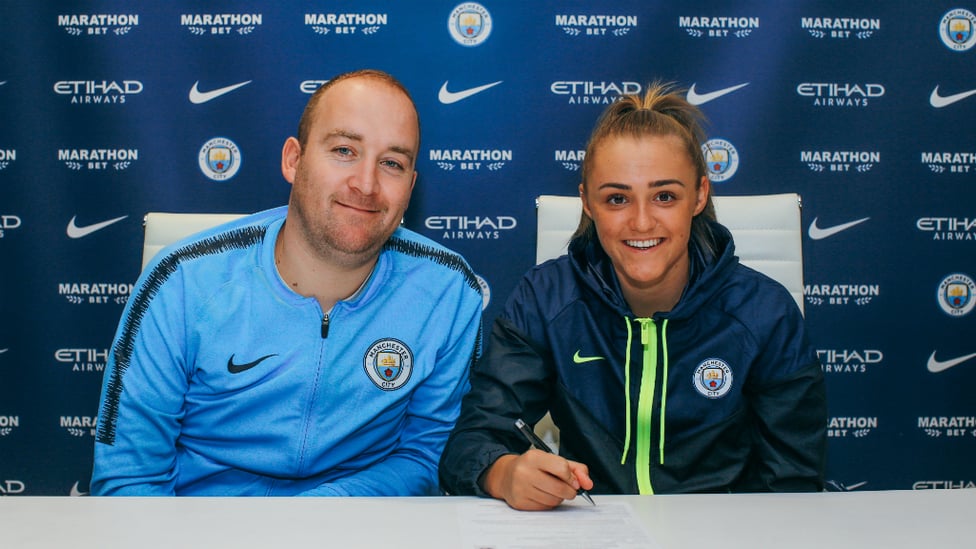 DELIGHTED : All smiles as Georgia puts pen to paper, alongside Nick Cushing