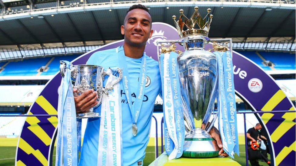 IMPRESSIVE HAUL : Danilo poses next to the Premier League and Carabao Cup in May 2018
