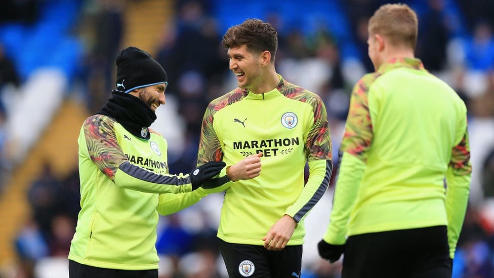 ALL SMILES : Aguero and Stones share a joke during the warm up.