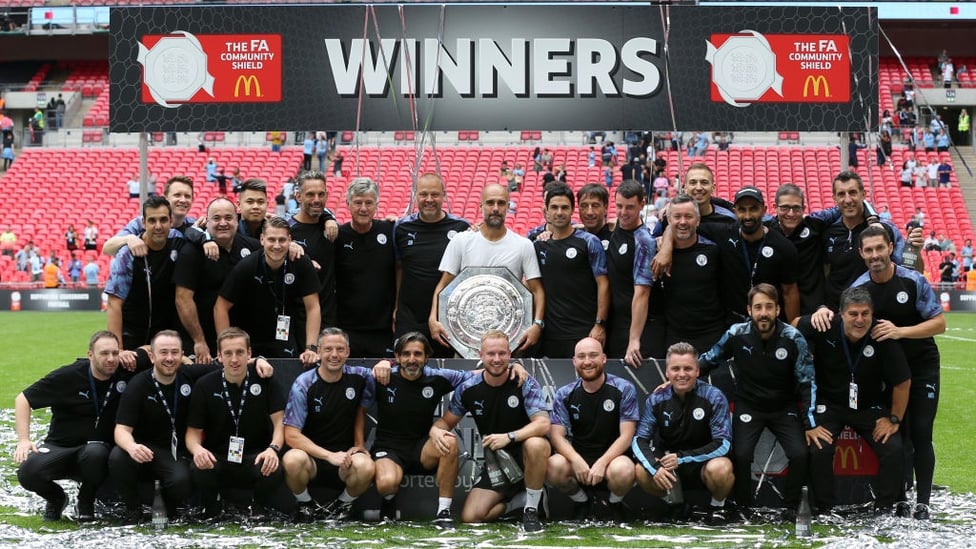 WINNING FORMULA : Pep Guardiola's staff pose with the latest trophy in their collection.