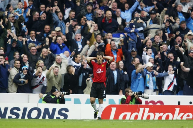 Man City fans celebrate in front of Gary Neville 