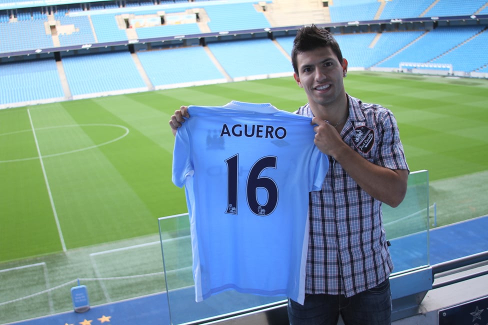 HAPPY TIMES : Aguero smiles as he poses with his new City shirt in 2011