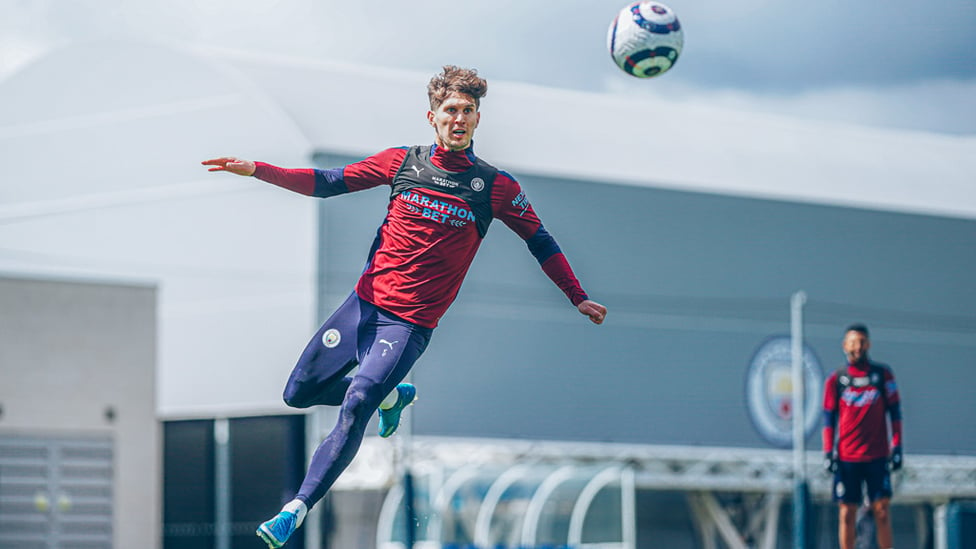 EYES ON THE PRIZE : A focused John Stones rises high.