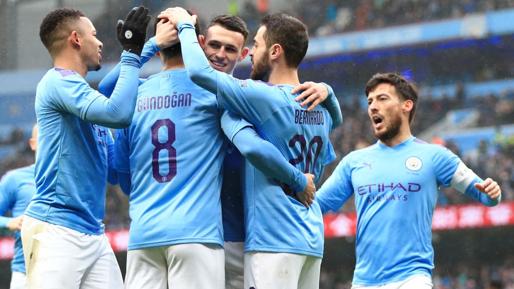 GROUP HUG: The players share the love after Gundogan's opening goal.